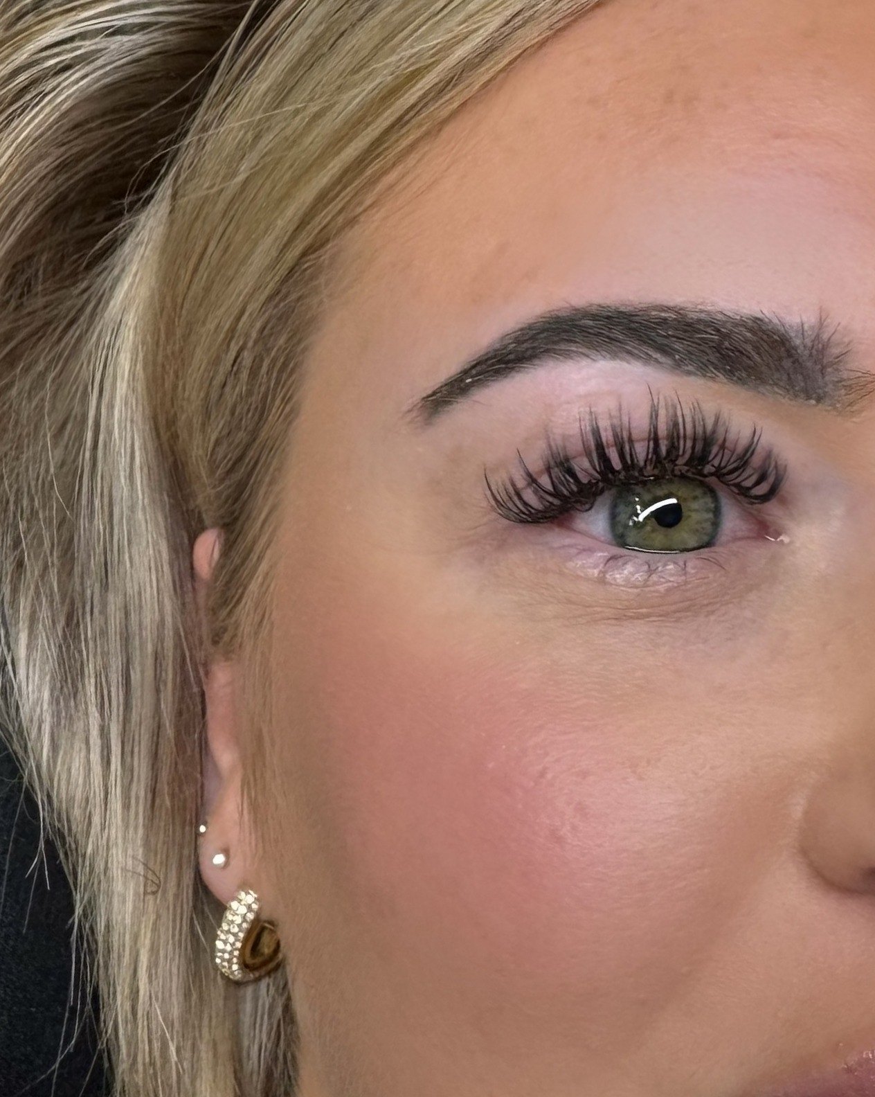 Volle wimperset met verzorgde wenkbrauw bij een blonde klant
